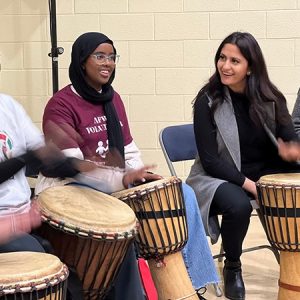 Minister Khera engaging in a drumming circle with the African Family Revival Organization.